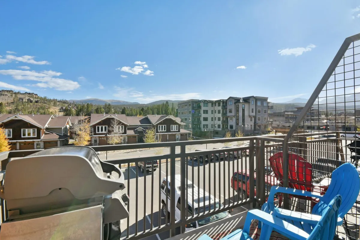 A private balcony with comfortable seating, a gas grill, and open views of the surrounding mountains. The scene highlights the ideal space for relaxing, al fresco dining, and enjoying fresh Rocky Mountain air.