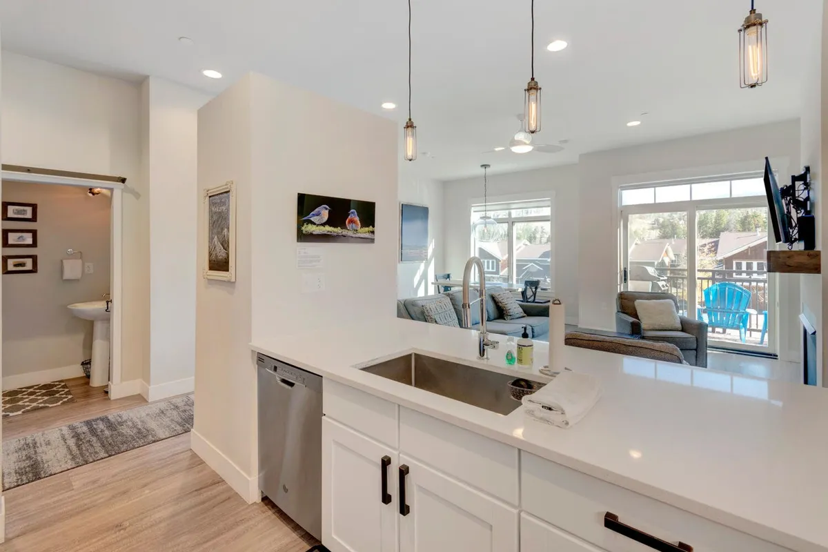 A modern kitchen with a generous island and abundant seating, framed by expansive windows. The layout encourages group cooking, casual chats, and entertaining, all within a bright, contemporary setting.